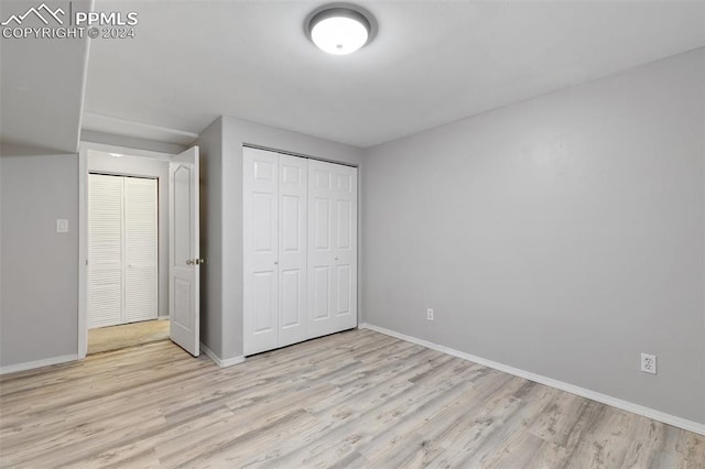 unfurnished bedroom with a closet and light hardwood / wood-style floors