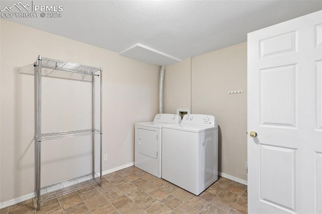 laundry room featuring independent washer and dryer and a textured ceiling