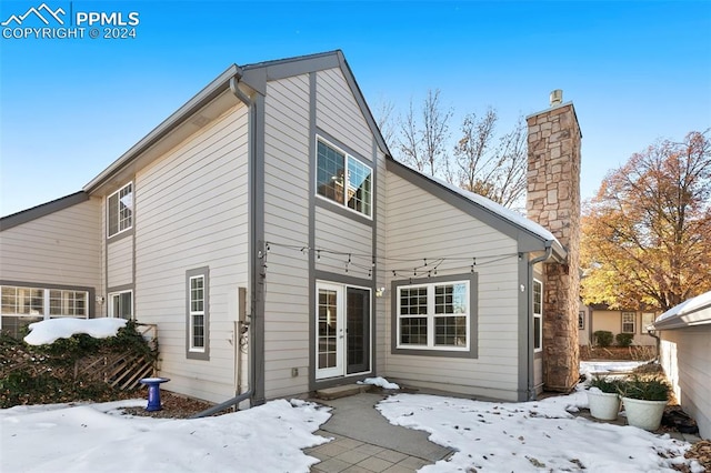 view of snow covered back of property