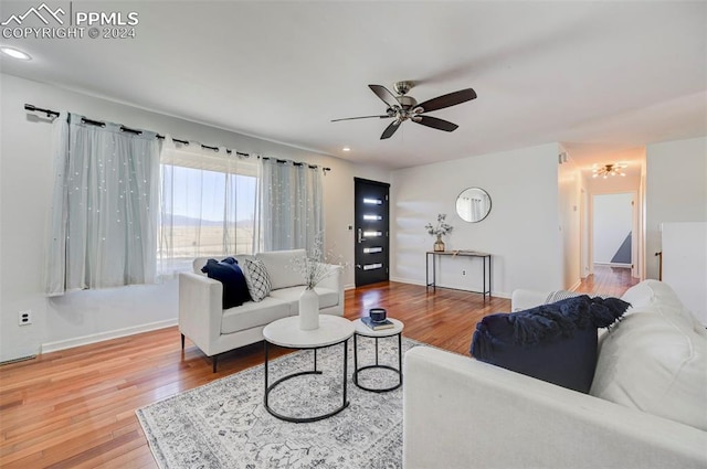 living room with hardwood / wood-style flooring and ceiling fan