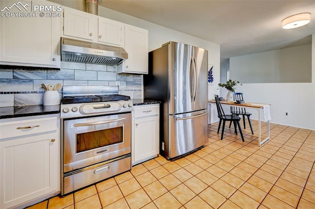 kitchen featuring backsplash, white cabinets, light tile patterned floors, range hood, and stainless steel appliances