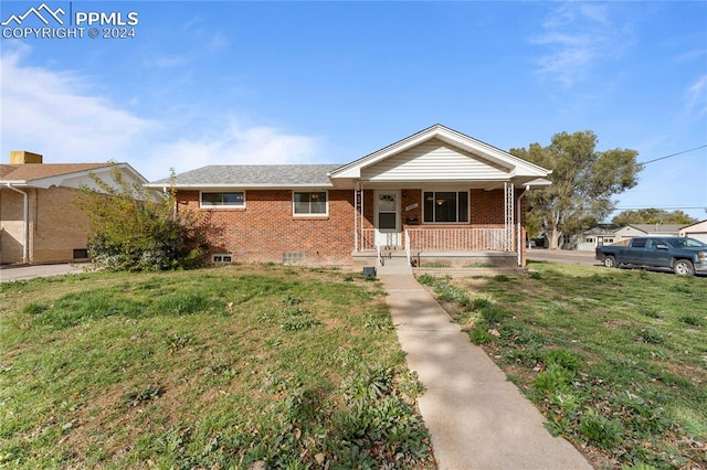 single story home featuring covered porch and a front lawn