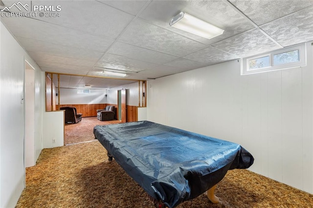 game room featuring wood walls, a drop ceiling, carpet floors, and pool table