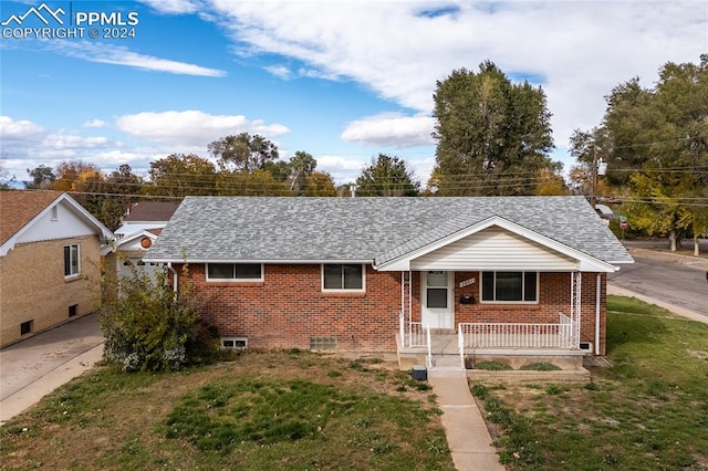 ranch-style home with a front lawn and covered porch