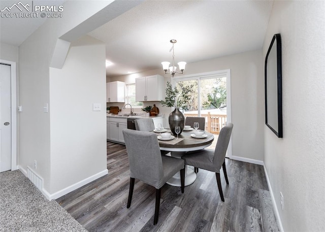 dining room with dark hardwood / wood-style flooring, a notable chandelier, and sink