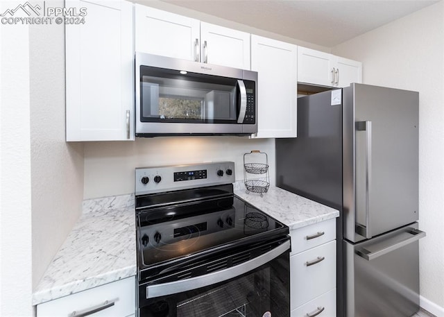 kitchen featuring white cabinets, light stone countertops, and appliances with stainless steel finishes