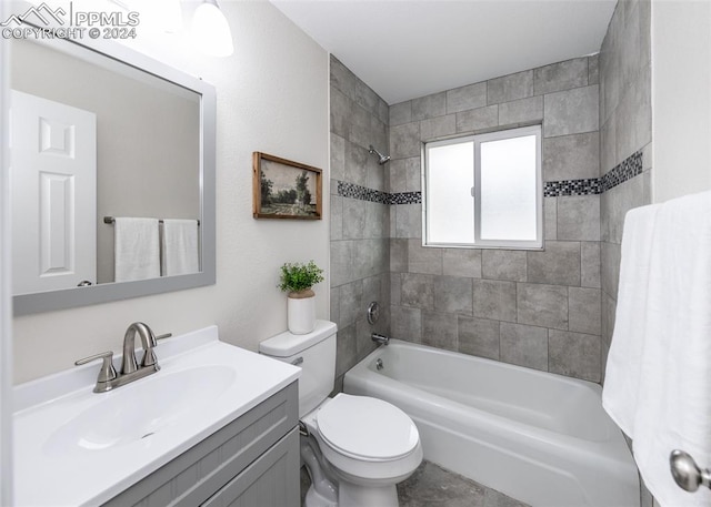 full bathroom featuring vanity, tiled shower / bath combo, and toilet