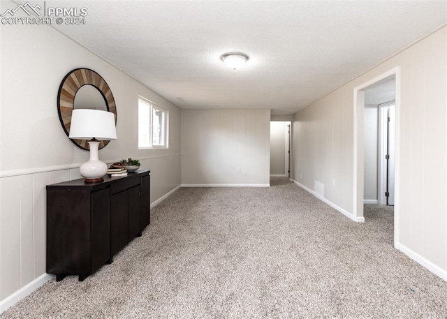 spare room with a textured ceiling and light carpet