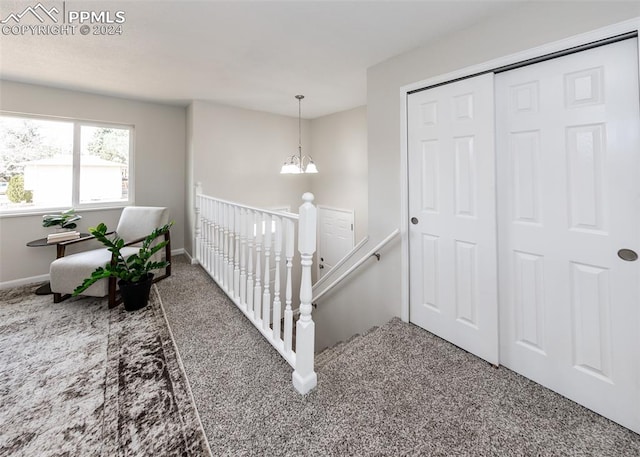 stairs featuring carpet flooring and an inviting chandelier