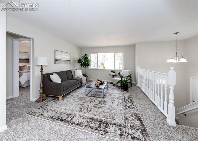 carpeted living room with a chandelier