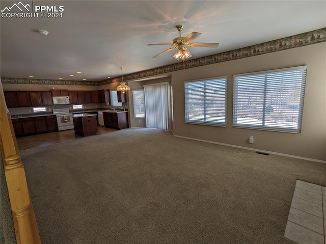 unfurnished living room featuring dark carpet and ceiling fan