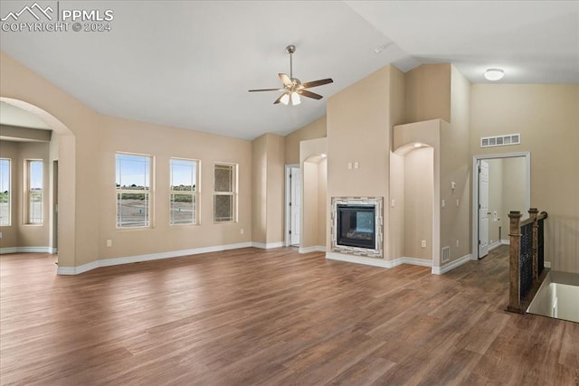 unfurnished living room with dark wood-type flooring, ceiling fan, and high vaulted ceiling