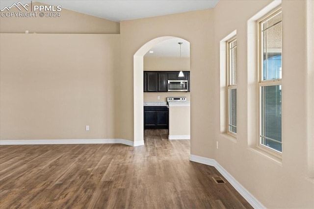 hallway featuring vaulted ceiling and dark hardwood / wood-style floors