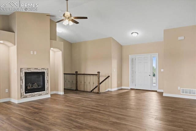 unfurnished living room with high vaulted ceiling, dark wood-type flooring, and ceiling fan