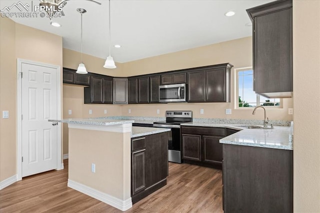 kitchen featuring hardwood / wood-style floors, sink, a kitchen island, and appliances with stainless steel finishes