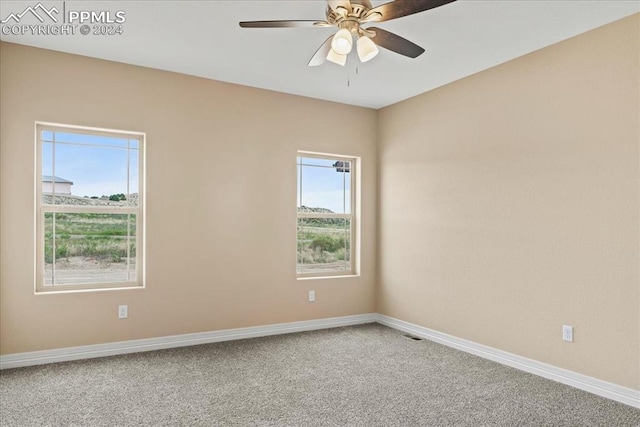 carpeted spare room featuring ceiling fan