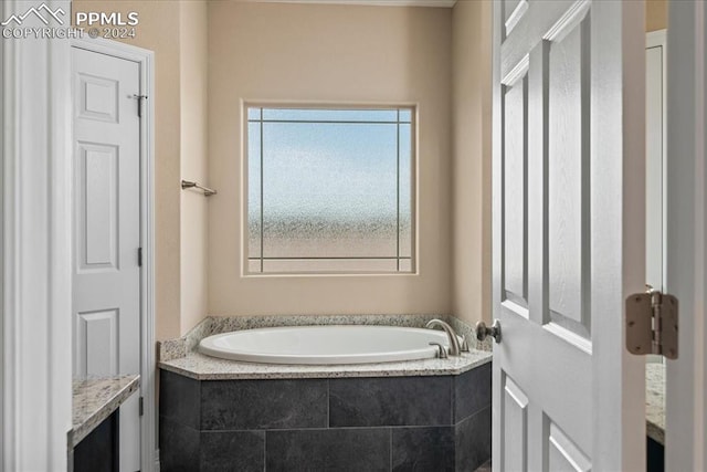 bathroom with vanity and tiled tub