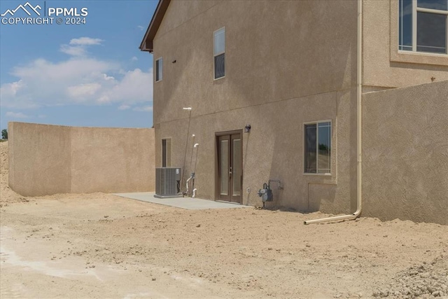 rear view of property with central AC unit and a patio area