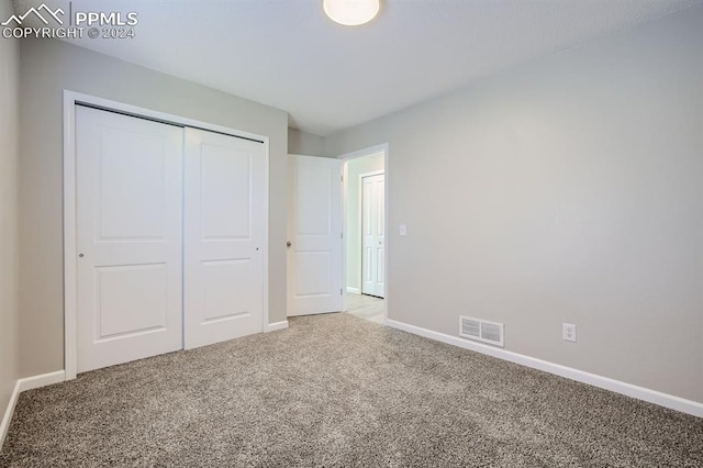 unfurnished bedroom featuring carpet flooring and a closet