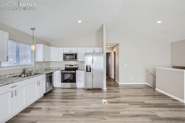 kitchen with stainless steel appliances, hanging light fixtures, sink, white cabinetry, and light hardwood / wood-style flooring