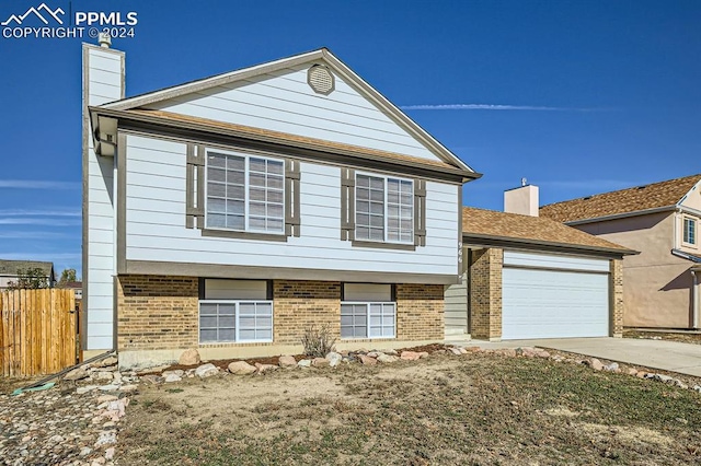 966 Daffodil St, Fountain, CO 80817 - view of front of home featuring brick siding, fence, an attached garage, and driveway
