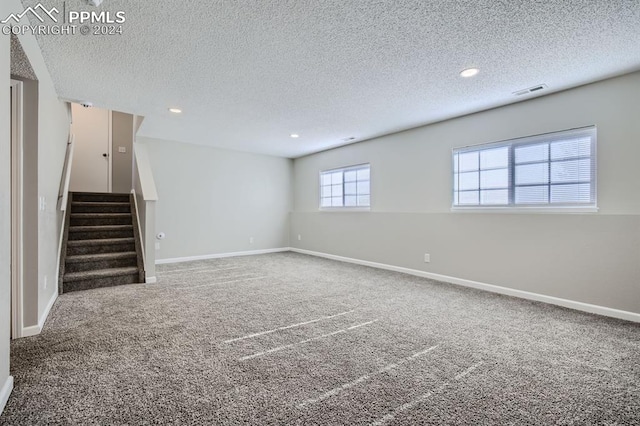 basement featuring carpet and a textured ceiling