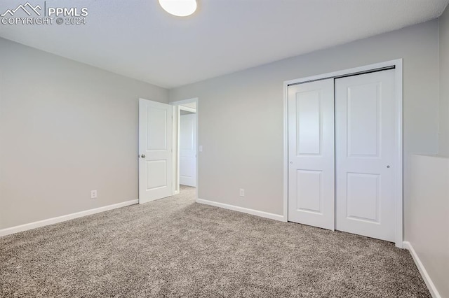 unfurnished bedroom with carpet flooring and a closet