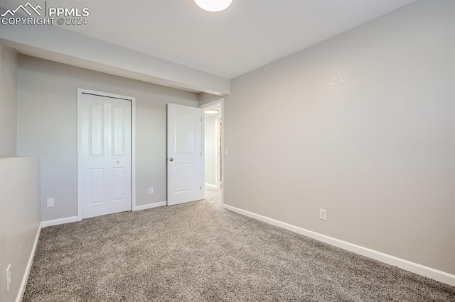 unfurnished bedroom with carpet and a closet