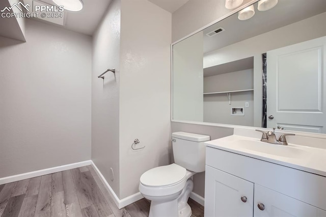 bathroom featuring hardwood / wood-style floors, vanity, and toilet