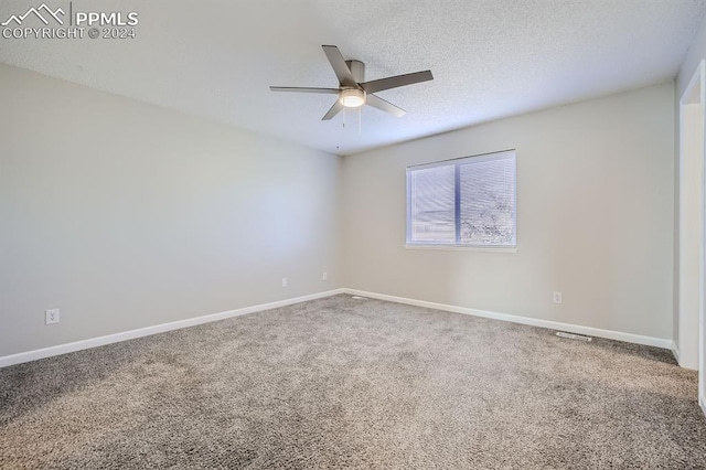 carpeted spare room featuring ceiling fan and a textured ceiling