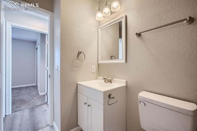 bathroom with vanity, hardwood / wood-style flooring, and toilet