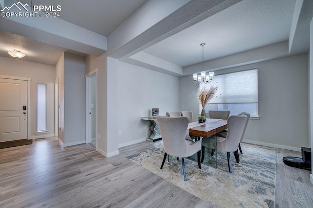 dining area with a chandelier and light hardwood / wood-style flooring