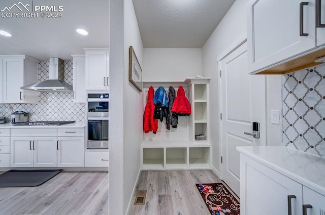 mudroom featuring a textured ceiling and light wood-type flooring