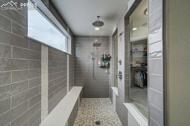 bathroom featuring a tile shower and tile walls