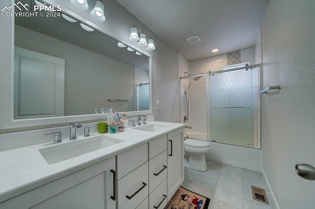 full bathroom featuring toilet, combined bath / shower with glass door, and vanity