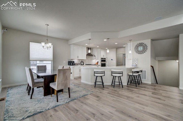 dining area with a notable chandelier and light hardwood / wood-style flooring