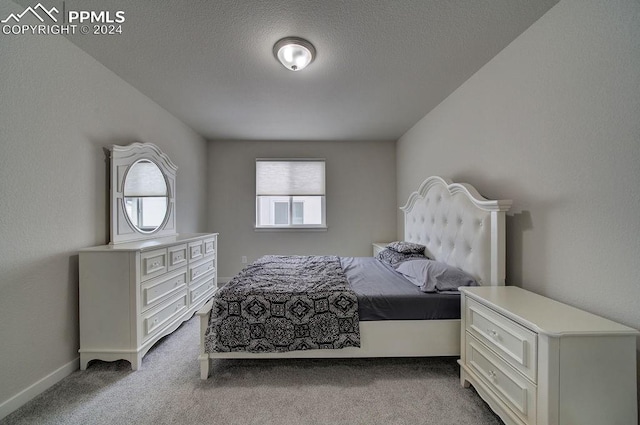 carpeted bedroom featuring a textured ceiling