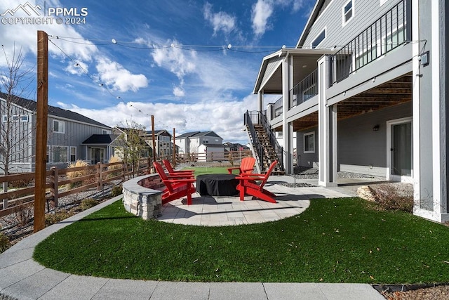 view of yard featuring a deck, a fire pit, and a patio area