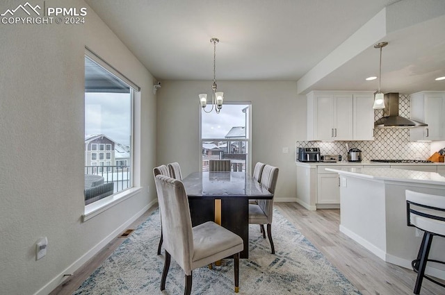 dining room with an inviting chandelier and light hardwood / wood-style flooring