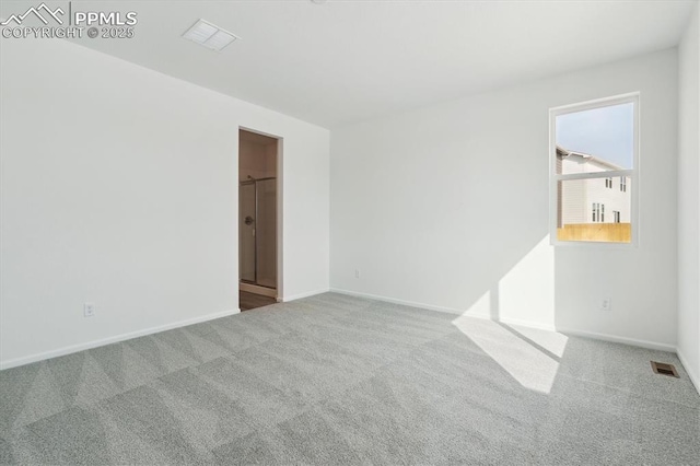 carpeted empty room with visible vents and baseboards