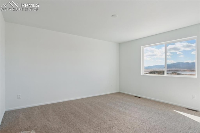 spare room with visible vents, carpet floors, and baseboards