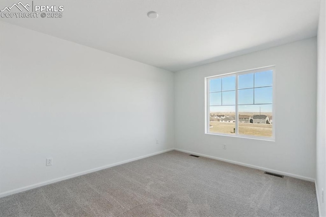 carpeted empty room featuring visible vents and baseboards