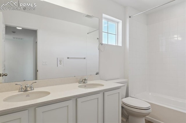 bathroom with double vanity, toilet,  shower combination, and a sink