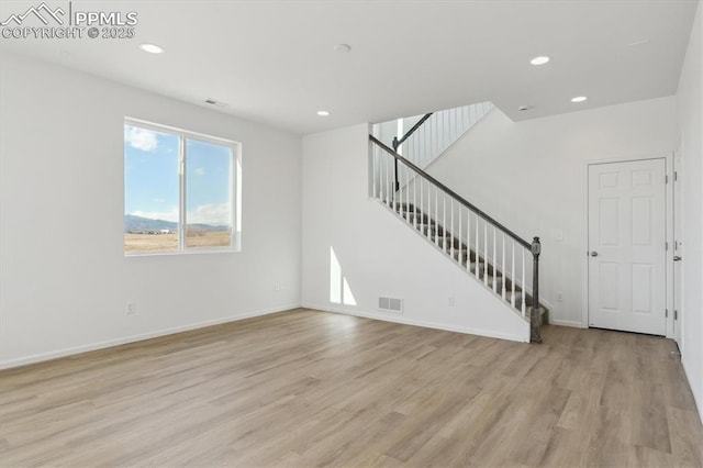 unfurnished living room featuring recessed lighting, stairway, light wood-style floors, and visible vents