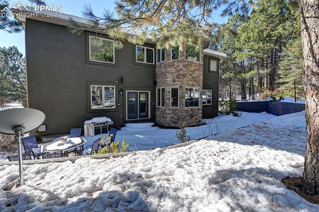 view of snow covered rear of property