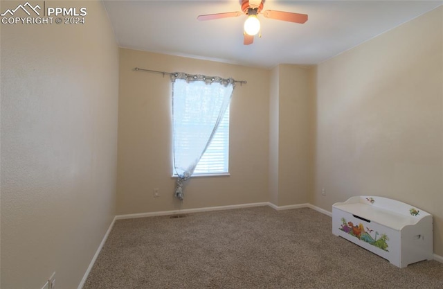 carpeted spare room with ceiling fan