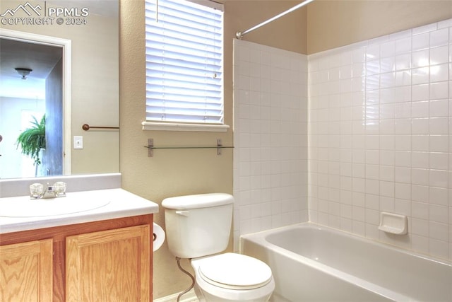 full bathroom featuring tiled shower / bath, vanity, and toilet