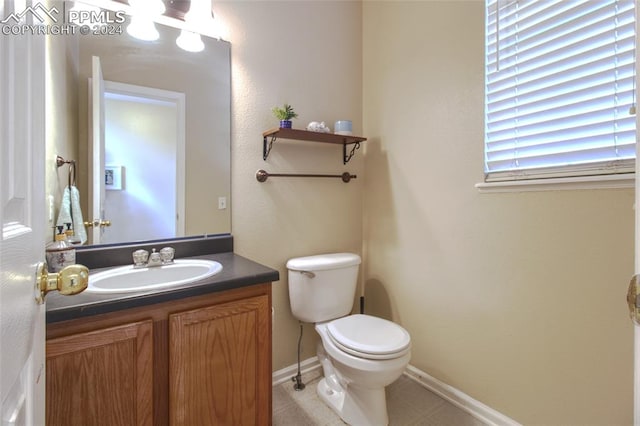 bathroom featuring tile patterned flooring, vanity, and toilet