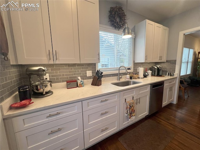 kitchen featuring white cabinetry, sink, stainless steel dishwasher, and decorative light fixtures