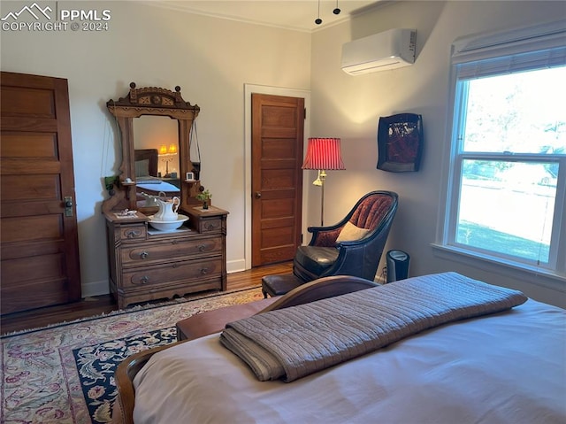 bedroom featuring hardwood / wood-style floors, a wall mounted air conditioner, and crown molding